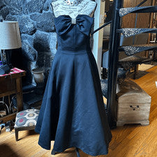 Elegante vestido negro sin tirantes con detalle de lazo de Nila Martin
