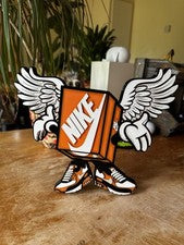 Exhibición de personajes de caja de zapatos con alas Nike 3D - Letrero coleccionable de arte de zapatillas.